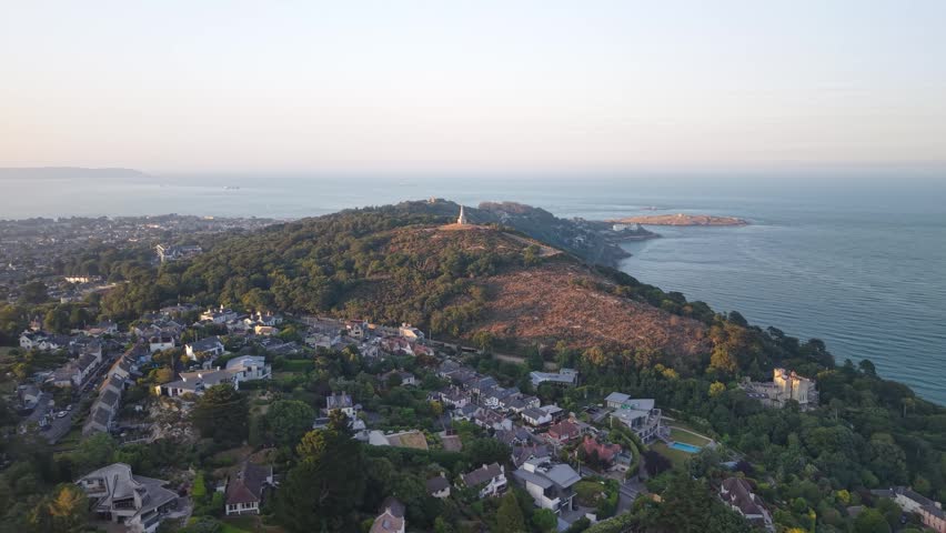 Aerial of Killiney Hill Obelisk at sunset overlooking Dublin Bay, coastal Ireland