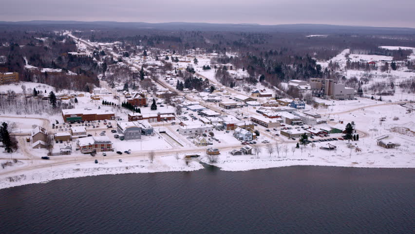 Drone footage flying over Huron Bay toward the lakeside town of L