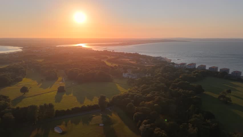 Mesmerizing sunset aerial above Howth Peninsula overlooking Dublin city and coast