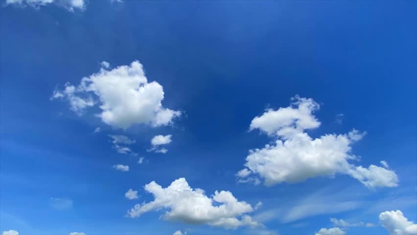 Beautiful time lapse of white cumulus clouds moving across a vibrant blue sky. Serene natural background for your projects.