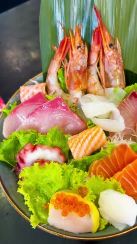 Premium Japanese sashimi platter featuring fresh salmon, otoro, salmon belly, sweet shrimp, squid, octopus, and surf clam served on ice