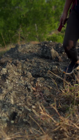 Close-up of male legs stepping carefully across rocky terrain on a desert hillside, illustrating hiking, outdoor adventure, physical endurance, and challenging natural landscapes.