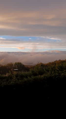 Golden Sunset Over Rolling Hills With Trees and Mist at Dusk