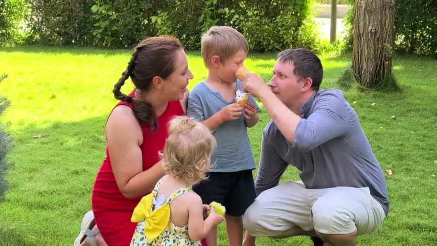 Parents and children enjoy ice cream together outdoors on a summer day, happy family moment, sweet treat, childhood joy, relaxed leisure.
