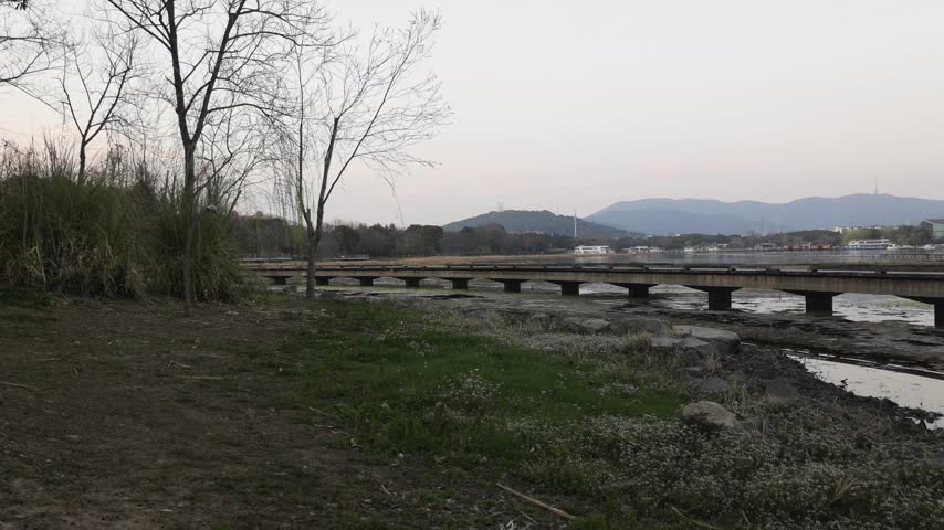 Tranquil Sunset Over a Scenic Bridge at Riverside with Natural Surroundings