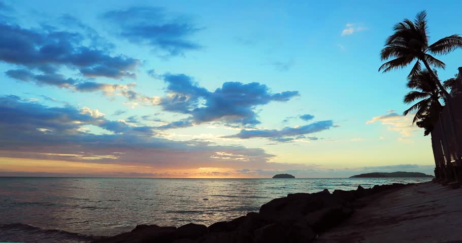 Spectacular sunset over the sea with aplm trees silhouettes in Malaysia