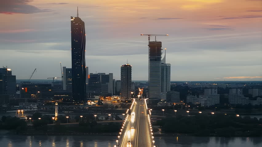 Vienna night aerial skyline view featuring the illuminated Donau City skyscrapers, modern high-rise architecture and city lights during blue hour in the Austrian capital.