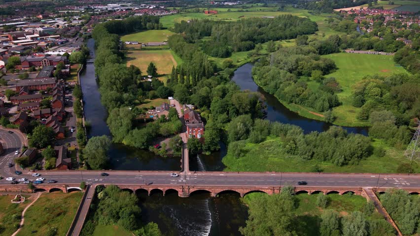 Scenic aerial view of stone bridge over river surrounded by greenery