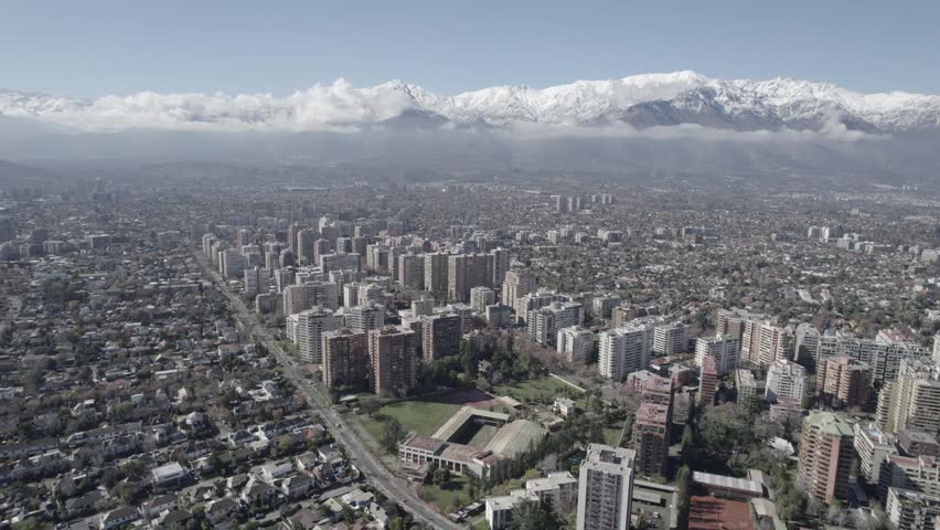 Aerial Drone Shot Of Santiago De Chile Cityscape Facing The Snow Covered Andes Mountains