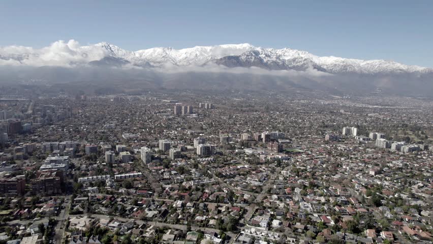 Drone Pull Back Shot Revealing Santiago Cityscape And Snowy Andes Mountains