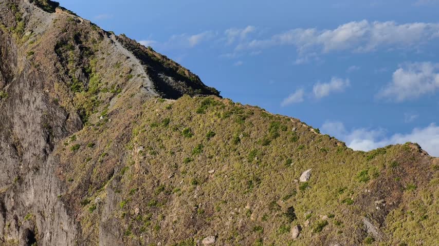 Panoramic view of a vast inactive volcano crater rim surrounded by scenic mountain landscape.