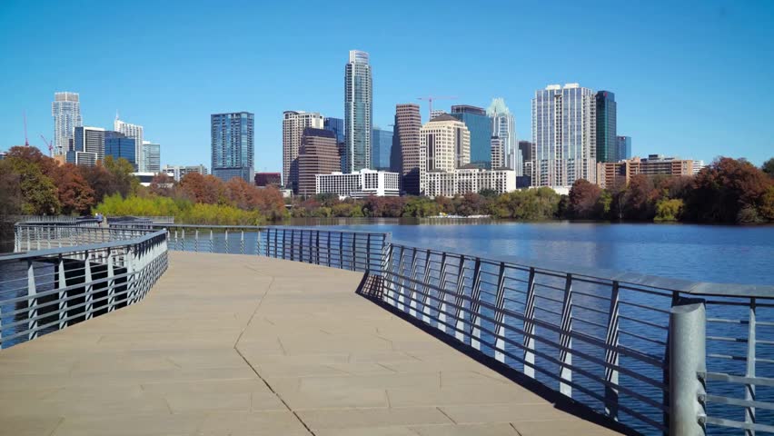Austin skyline view across Lady Bird Lake from the Boardwalk trail during a bright sunny day