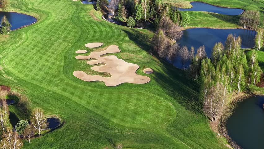 Golf course fairway surrounded by lakes and trees