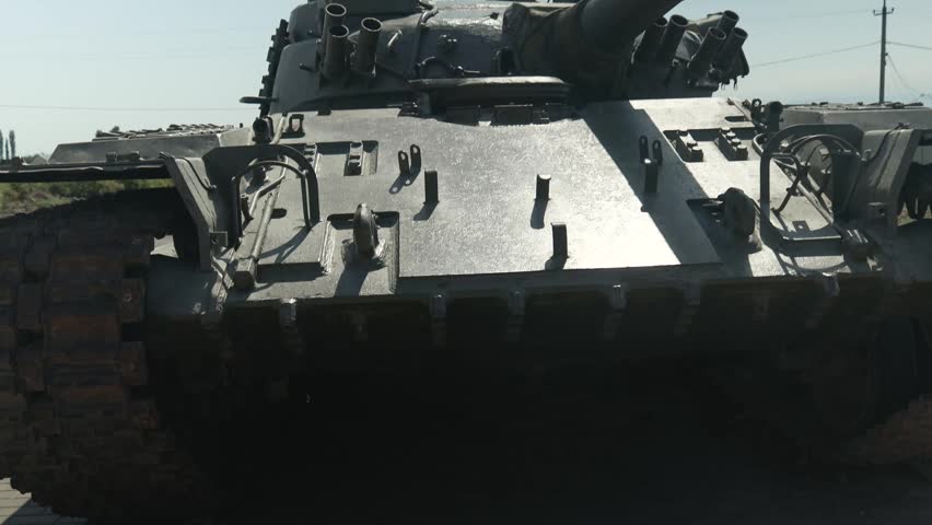 A military tank is parked along the roadside, awaiting its next mission.