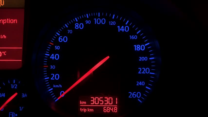 Instrument cluster featuring distinctive blue backlighting with red gauge needles.