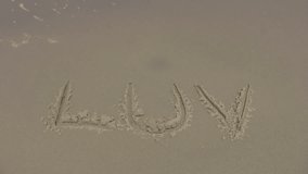 Video of the word LUV sratched in sand of beach. Washed away by wave. Gulf of Mexico. Clean sand. Don Despain of Rekindle Photo