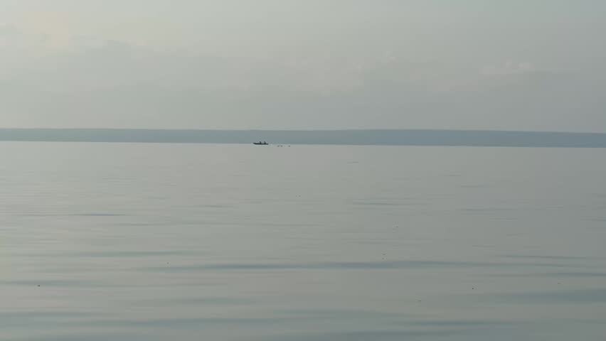 Speedboat Gliding Across Calm River Water Under a Moody Cloudy Sky