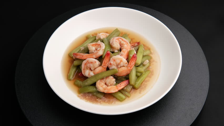 Stir fried lotus stems(Lily water) with fresh shrimp in white plate.Thai food.