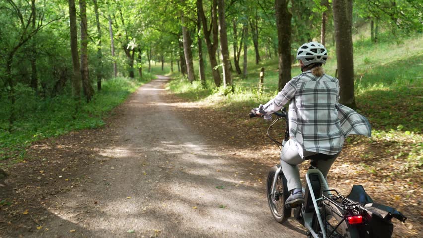 Cyclist Riding Electric Bicycle Along Forest Trail