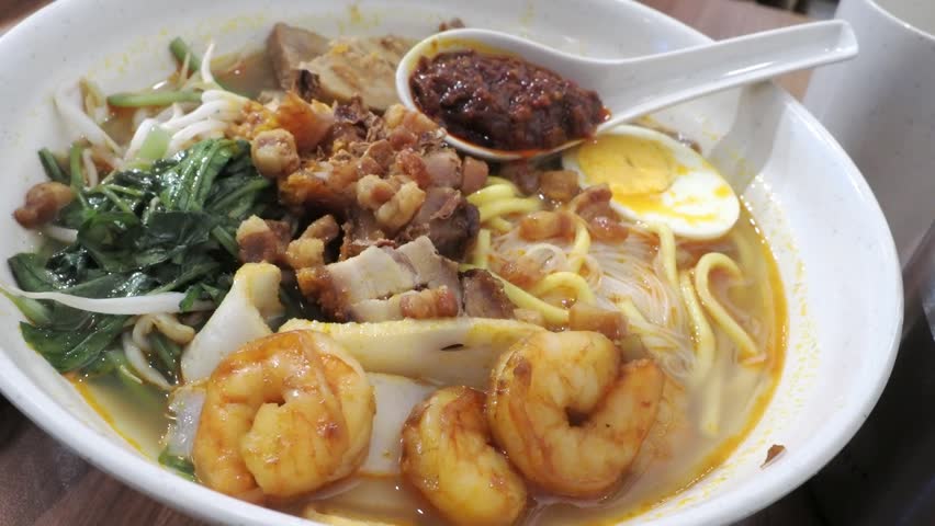 Bowl of Hokkien Har Mee (Prawn Noodles), a rich, umami-packed Malaysian and Singaporean noodle soup dish. Mix of egg noodles, rice vermicelli, with prawns, sliced pork, bean sprouts, and boiled egg.