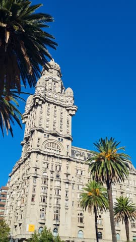 Vertical view of the iconic Palacio Salvo in Montevideo, Uruguay, under a clear blue sky. The historic landmark showcases Art Deco architecture, urban charm and the vibrant character of the city