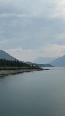 White Pass and Yukon Route historic train traveling along a lake shoreline in Yukon, Canada
