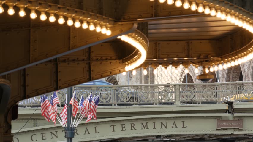 Grand Central Terminal on 42 street, New York City Manhattan Midtown. Railway building entrance in United States. American public railroad transport. Retro vintage station exterior. Bridge and flags.