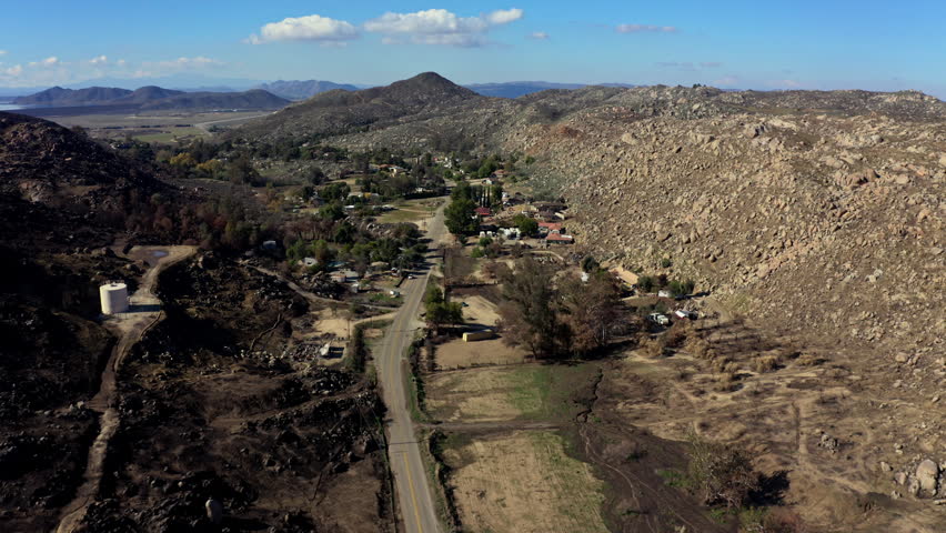 Drone view of wildfire damaged location in San Bernardino, California with the mountains in the background