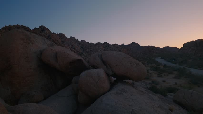 Wide pan at last light of sunset in majestic rock formations of Joshua Tree National Park