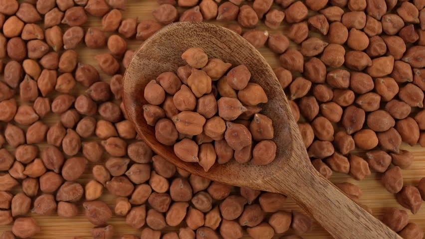 Chickpeas in a wooden spoon closeup.