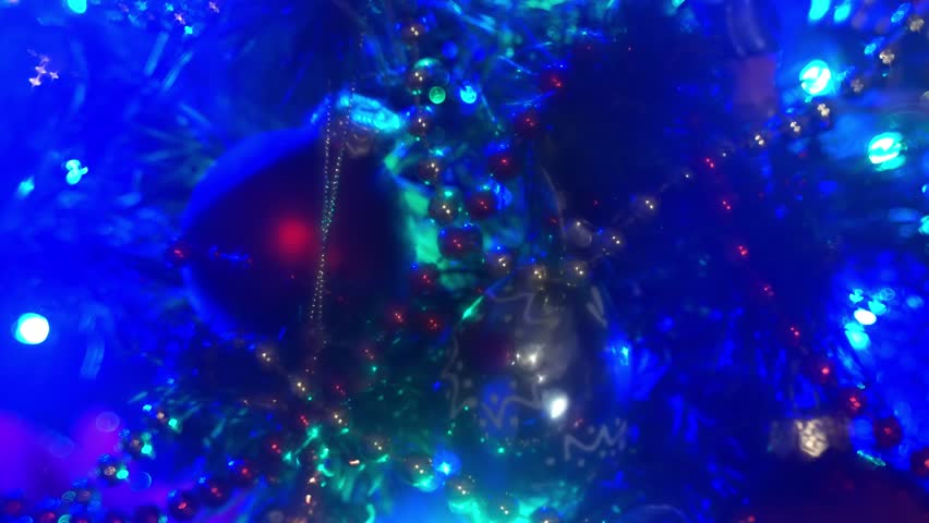 Close-Up Of Decorated Christmas Tree With Glass Ornaments, Twinkling Lights And Gold Bead Garland.
