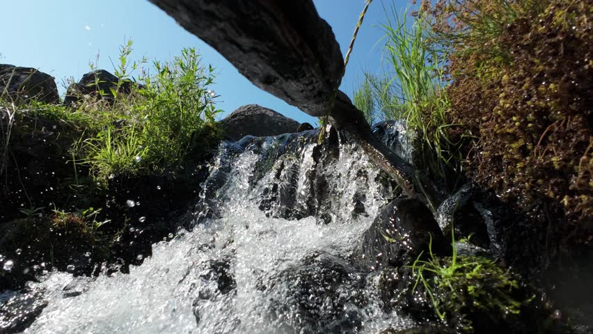 Water Flowing Over Small Rocky Waterfall Under Stone Bridge