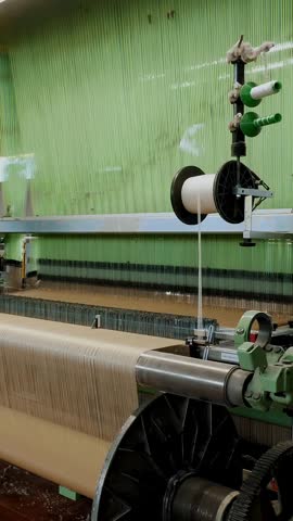 Weaving loom. Textile factory equipment. industrial weaving loom machine in working process, at a textile factory. Weaving.