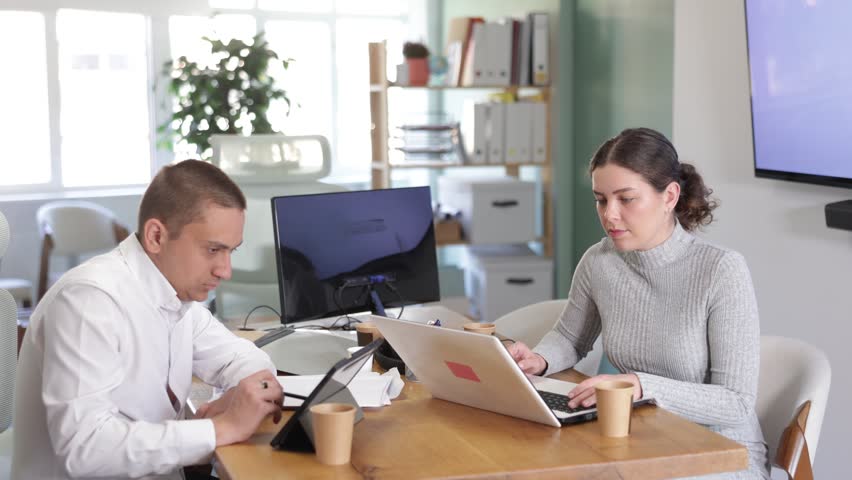 Portrait of two business colleagues chatting about work in office. High quality 4k footage