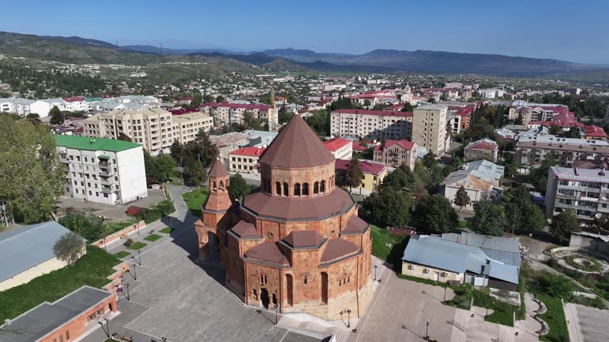 An aerial view of a city with buildings, green spaces, and distant mountains. Calm, clear day Azerbaijan drone