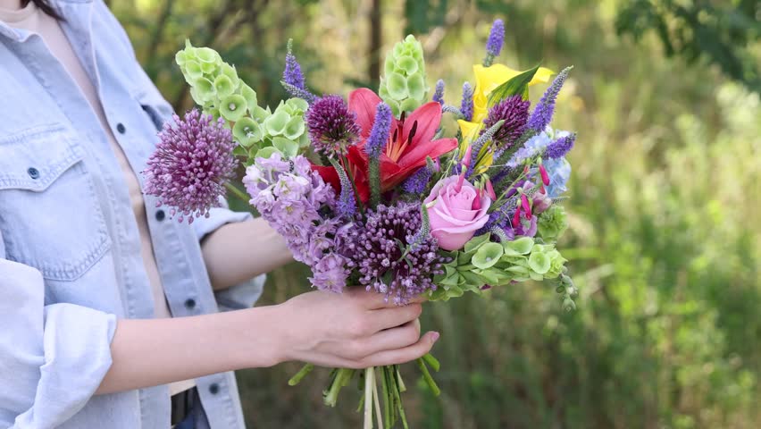 Woman with bouquet of beautiful summer flowers outdoors, closeup