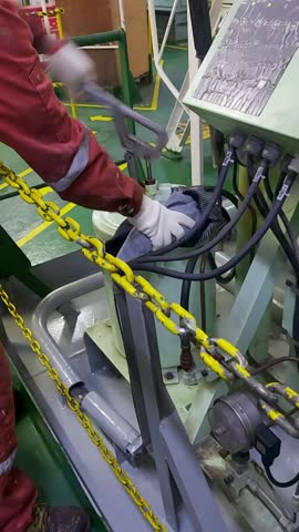Ship oiler performing maintenance by applying grease to steering gear using manual grease pump in engine room. Maritime crew conducting routine lubrication for vessel steering system. Preventive maintenance on cargo ship.