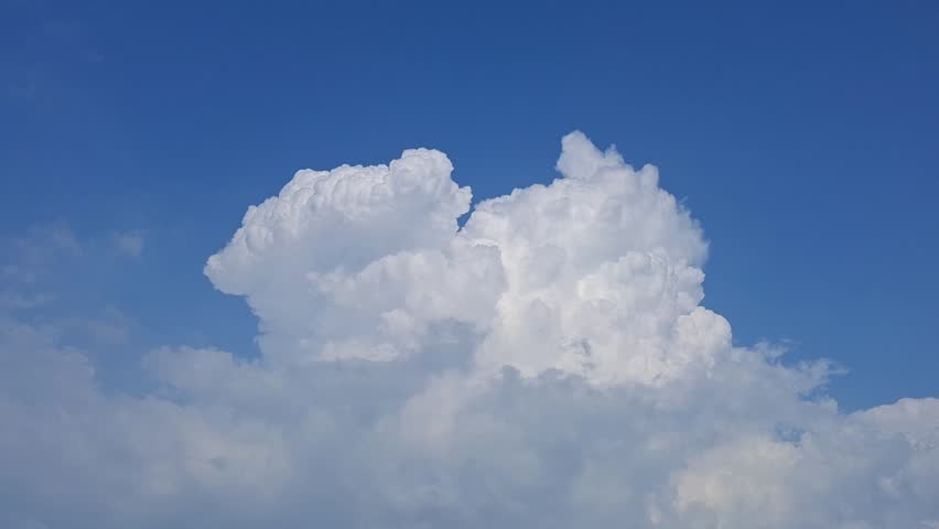 Single Puffy White Cumulus Cloud in Vibrant Blue Sky
