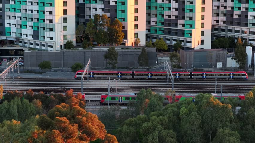 Adelaide CBD, South Australia, 9 Jul 2026 – 4K aerial drone footage of railway corridor, commuter trains, modern skyline, office towers and golden sunset cityscape
