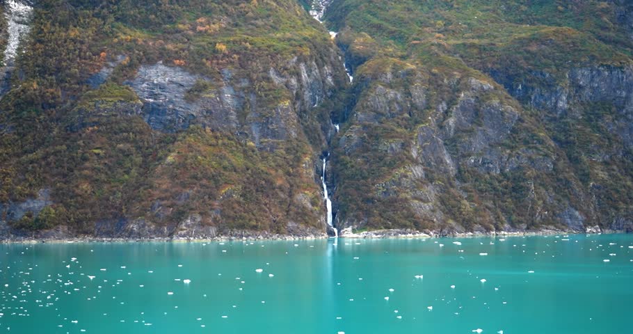 Long waterfall through moss covered mountain in Tracy Arm Fjord, Alaska