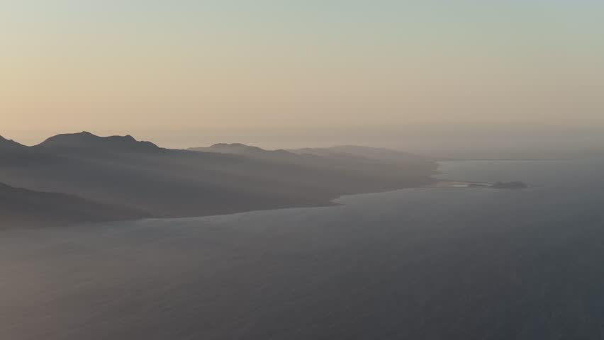 Aerial view of misty mountains and coastline near San Evaristo, Mexico.