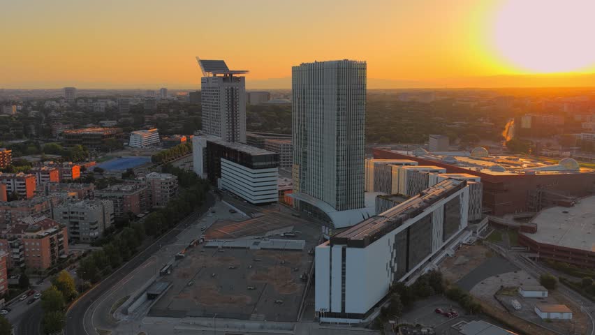 Aerial view of the modern EUR district skyscrapers illuminated by the warm golden hour light in Rome, Lazio, Italy.