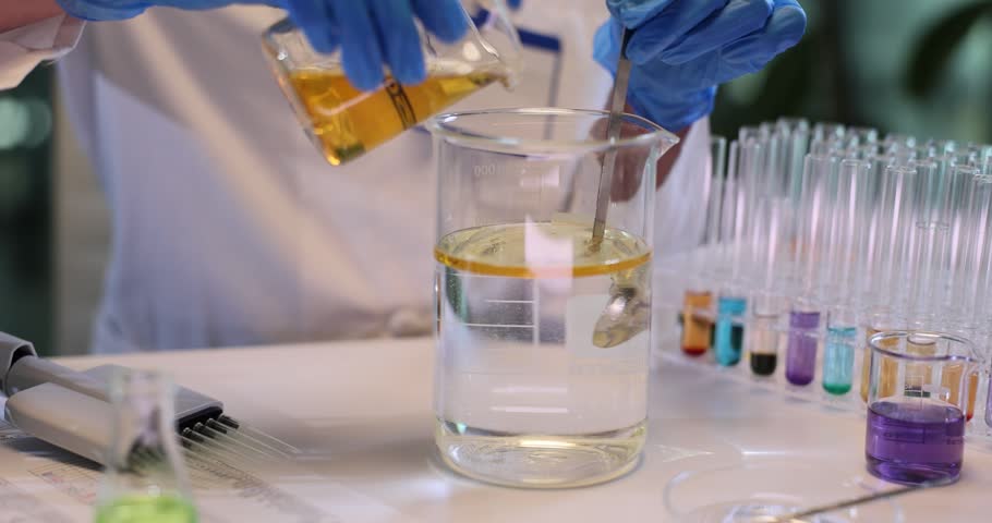 Woman chemist stirs oil and water in large beaker in research lab. Scientist in gloves analyzes reaction of fluids in agricultural center slow motion