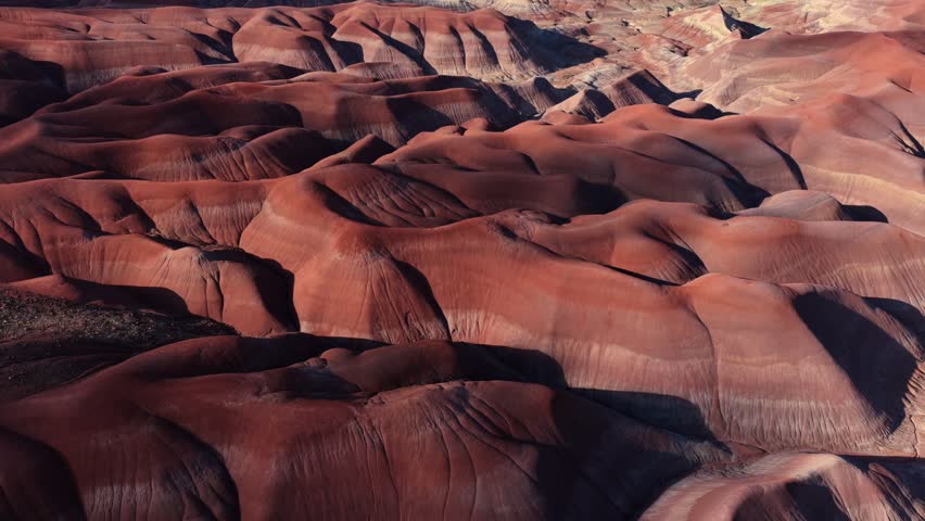 Aerial view of the Painted Desert featuring deep red rock formations and eroded landscape near Winslow, Arizona, United States.