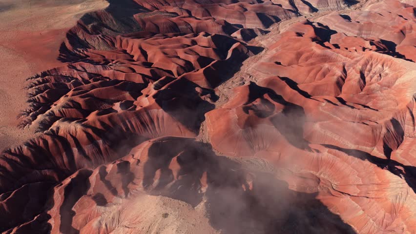 Aerial view of Painted Desert badlands with morning mist over the colorful geological formations in Winslow, Arizona, United States.