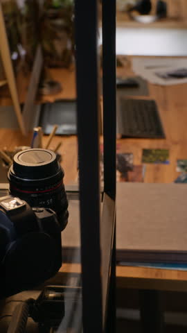 Vertical shot of creative workspace being revealed by camera pan, showing computer monitor with photo editing software and graphics tablet. Clip is ideal for promoting digital design courses