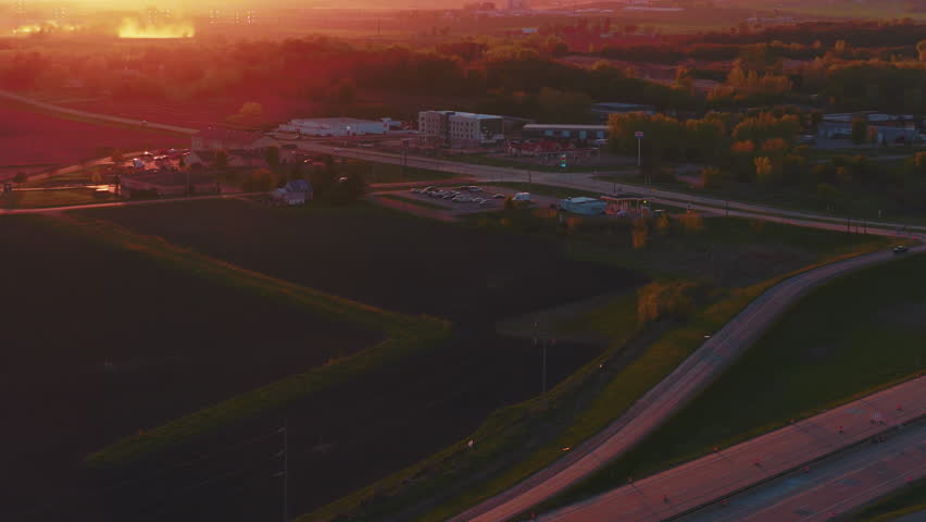 Warm golden hour aerial gliding over interstate traffic as a semi crosses DeForest, Wisconsin countryside.