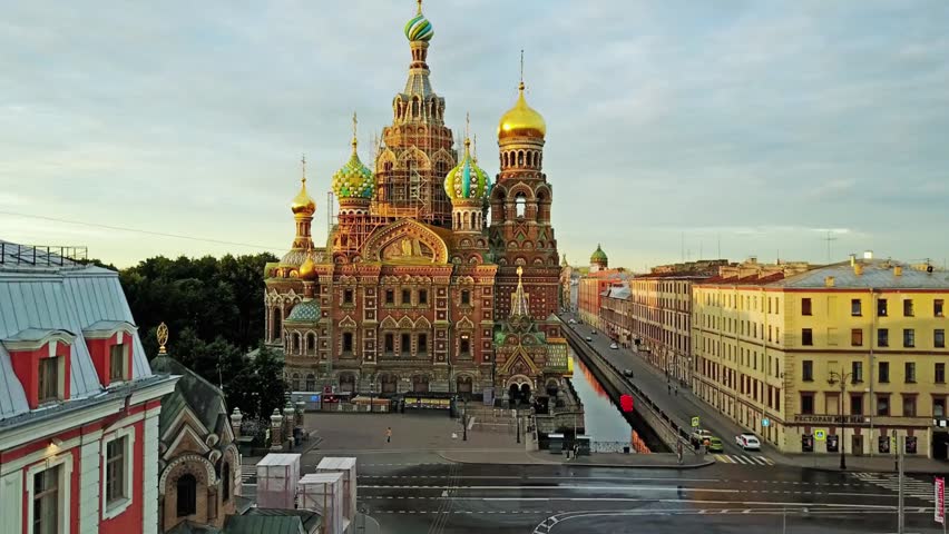 Aerial view of Saint Petersburg, Russia, showing a wide cityscape with rooftops, urban buildings, and streets. The elevated perspective captures the historic city structure and dense urban landscape in clear daylight.