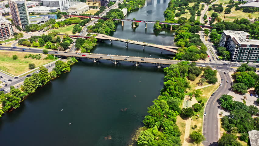 Aerial establishing shot of Austin, Texas skyline with slow camera uptilt, along Colorado river. Austin is the capital city of the U.S. state of Texas.