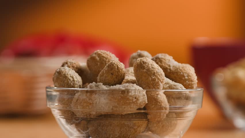 Peanuts in Salted Shell Man Cracking and Eating Salty Nuts as a Classic Bar Snack at Cafe